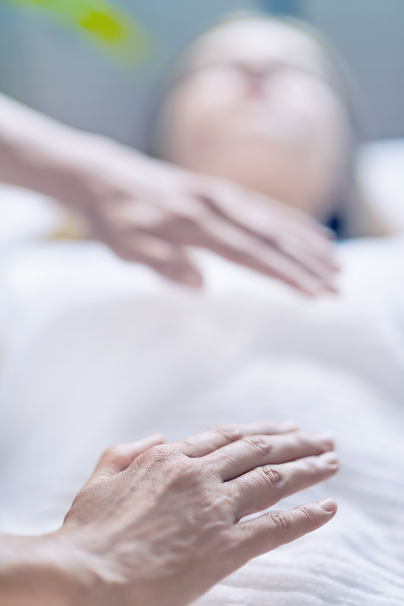 Massage Therapist Performing Reiki Treatment